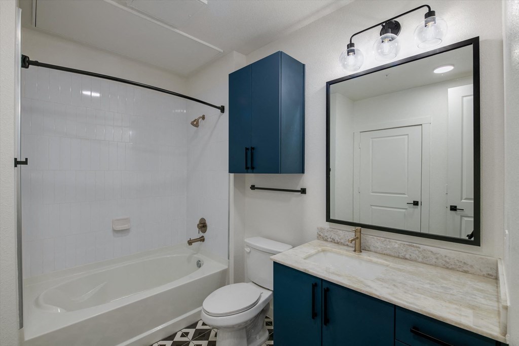 a white bathroom with a tub and a sink and a mirror