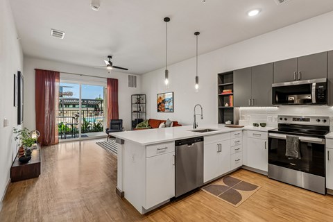 A modern kitchen with white cabinets and stainless steel appliances.