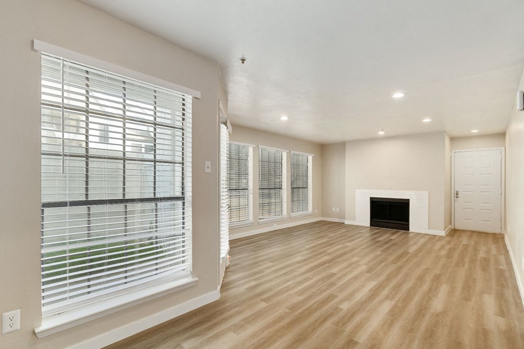 a living room with a fireplace and large windows