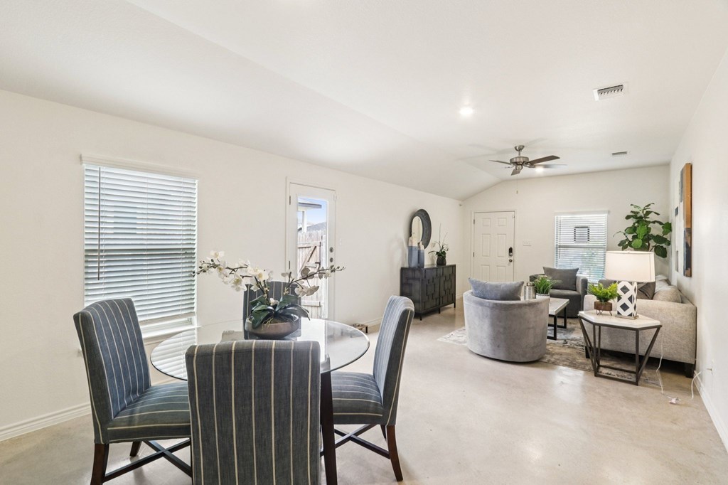 A dining room with a table and chairs.