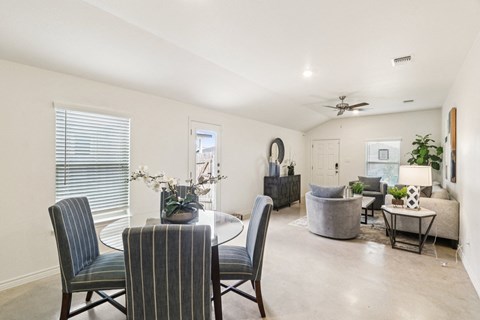 A dining room with a table and chairs.