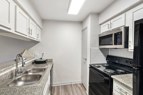 a kitchen with a sink and a stove and a microwave