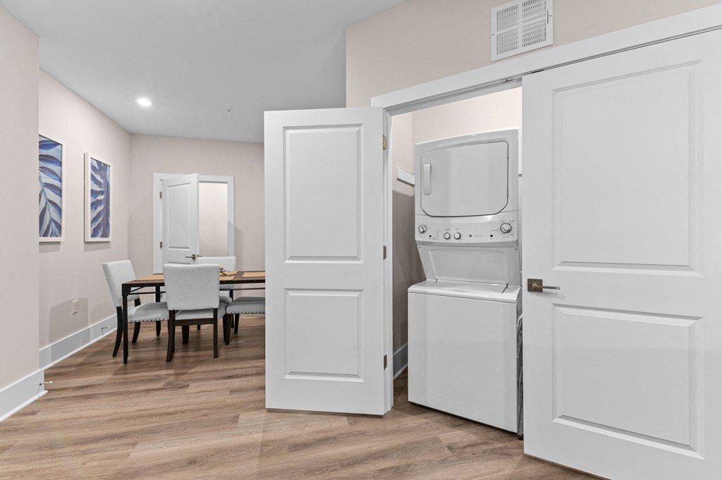 a laundry room with two washer and dryers and a dining room with a