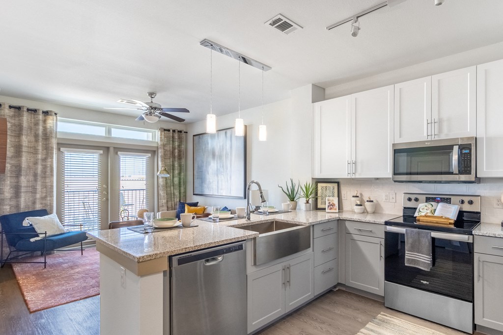 a kitchen with white cabinets and stainless steel appliances