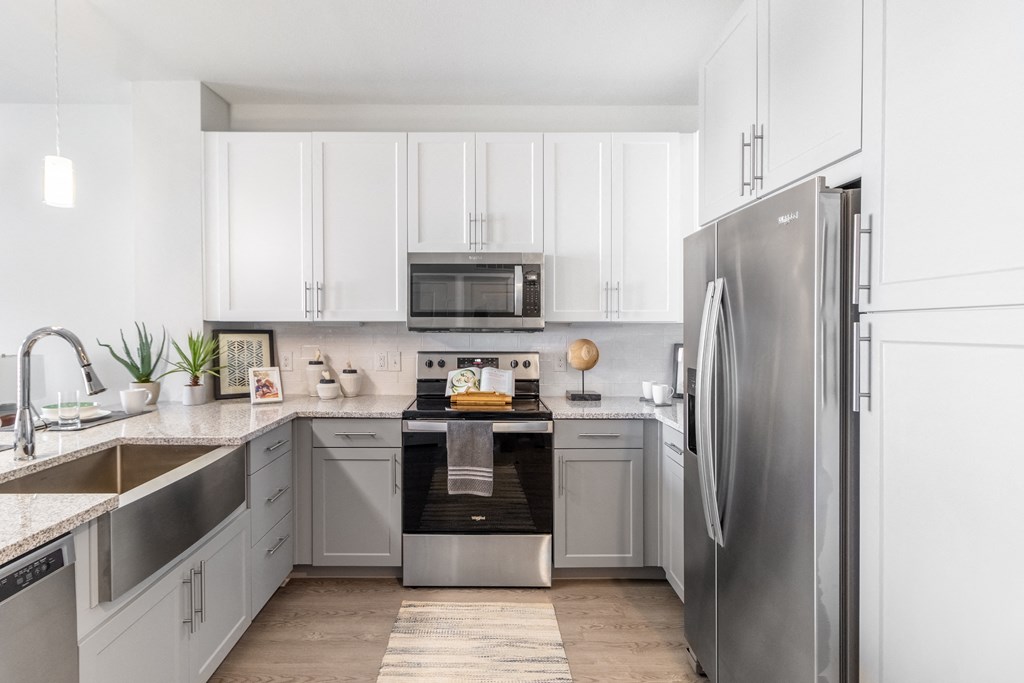 a kitchen with white cabinets and stainless steel appliances