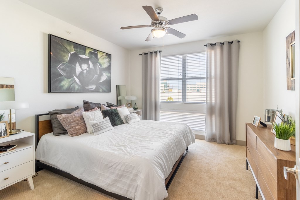 a bedroom with a large bed and a ceiling fan