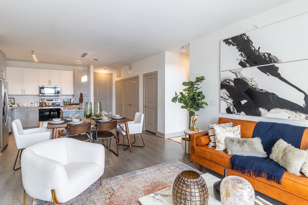 a living room and dining room with white walls and a large black and white painting on the