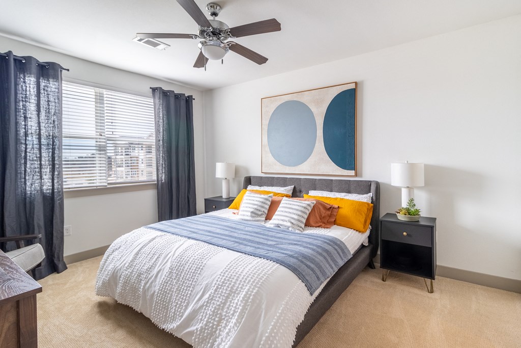 a bedroom with a large bed and a ceiling fan