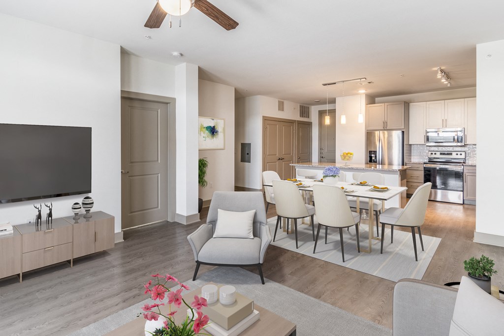 a living room and kitchen area with a dining table and chairs