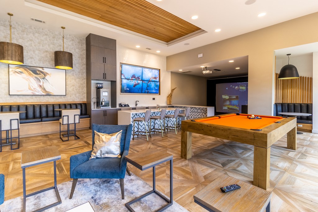 a games room with a pool table and bar