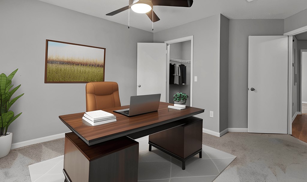 an office with a laptop computer on top of a desk