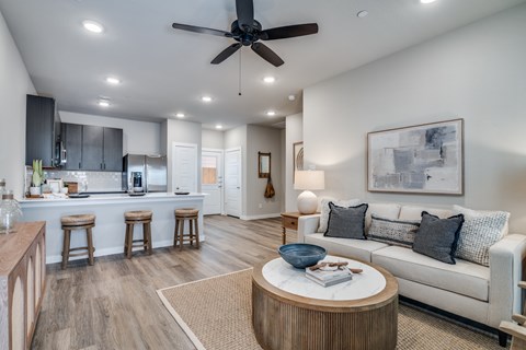 A modern living room with a ceiling fan and a white couch.