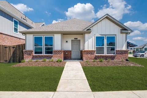 A house with a grey roof and a white door.