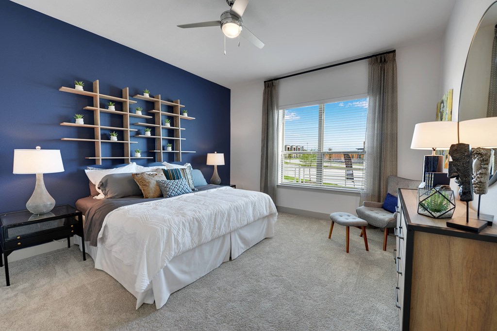 A bedroom with a large bed and a window overlooking a cityscape.