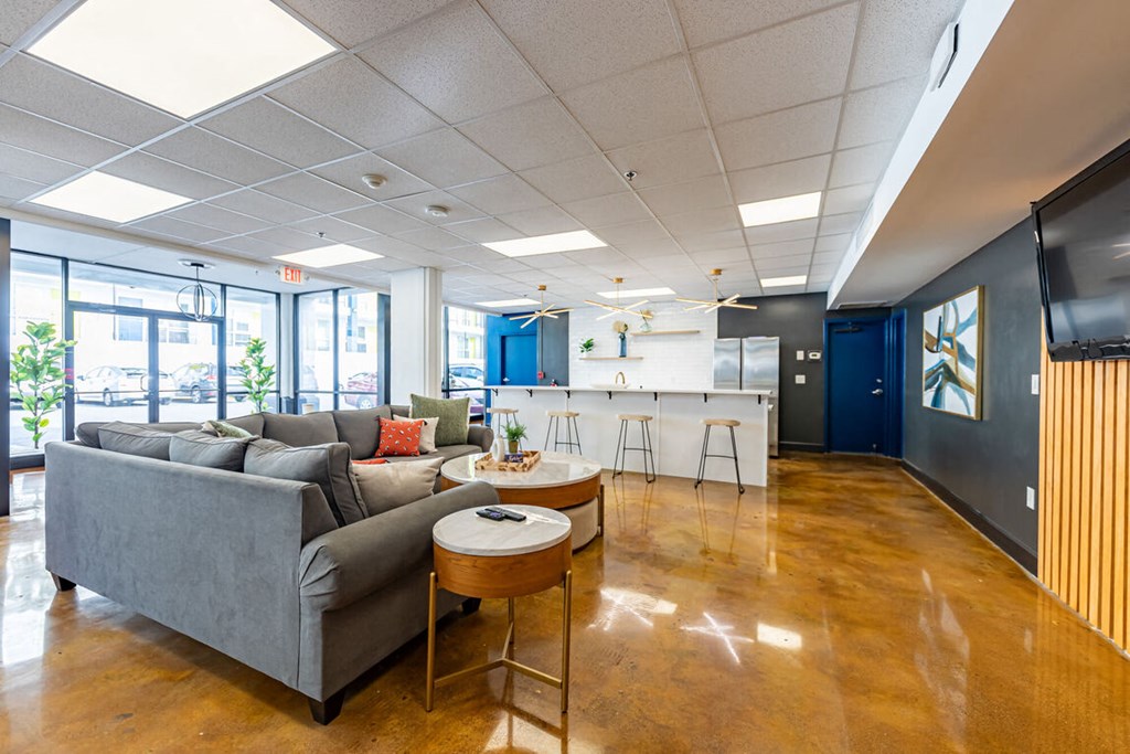 a living room with couches and a kitchen in the background