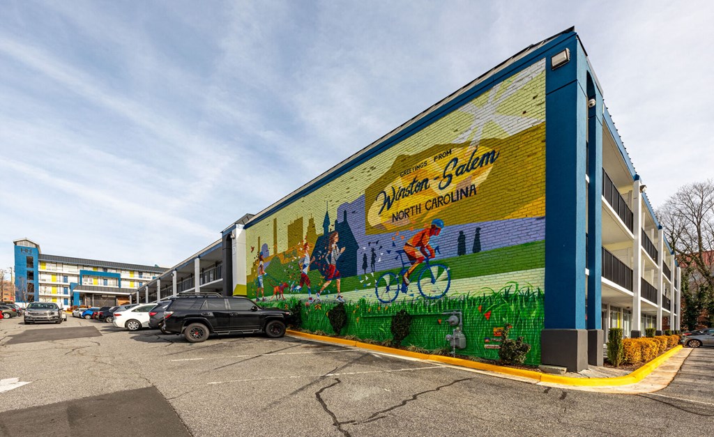 a mural on the side of a building in a parking lot