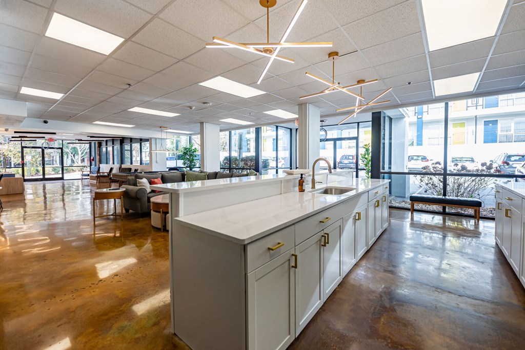 a large room with an island in the middle of a kitchen and a living room