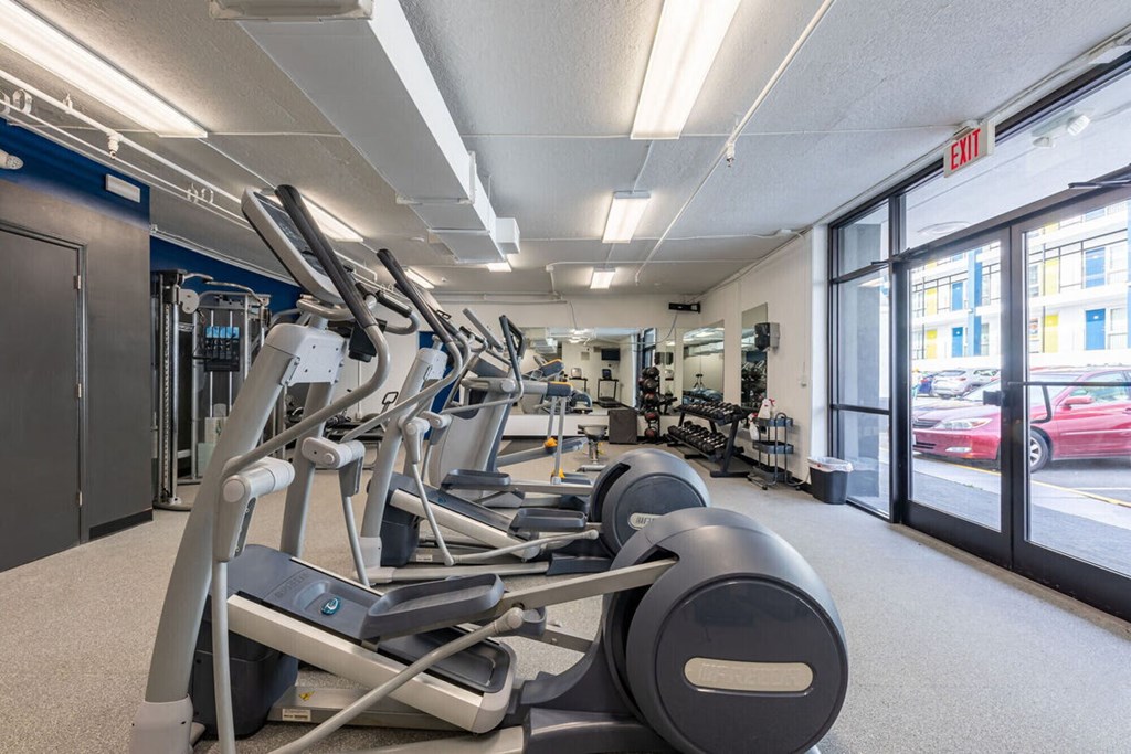 a gym with weights and cardio equipment in the lobby of a building