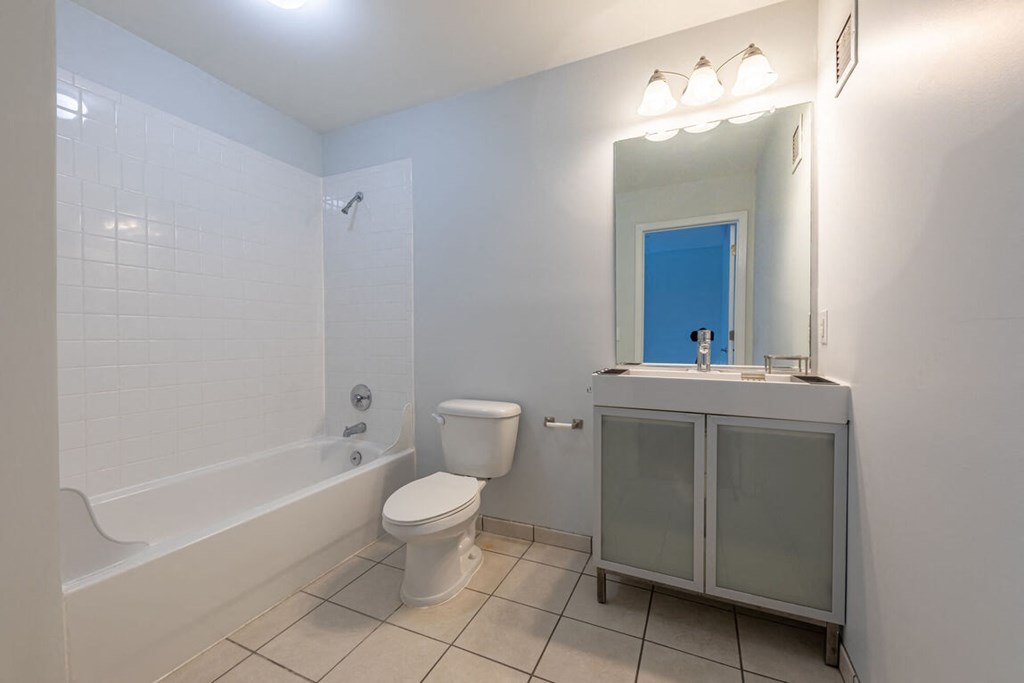 a bathroom with a toilet and a tub and a sink