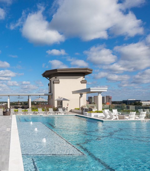 a swimming pool on the rooftop of a hotel with a building in the background