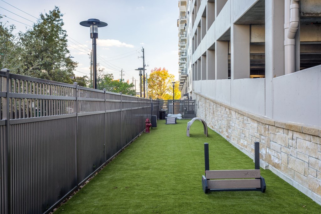 a small grassy area with benches and grass next to a building