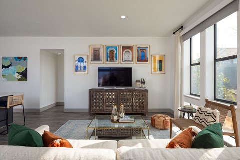 A living room with a white couch and a glass coffee table.