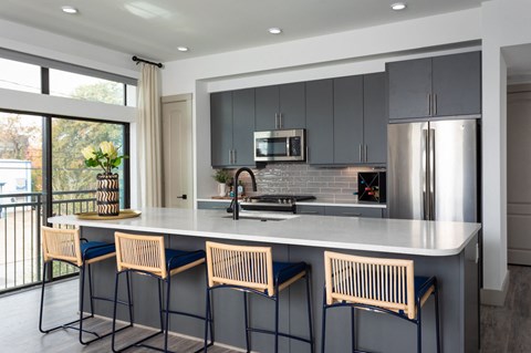 A kitchen with a bar area and stools.