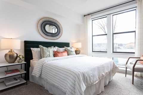 A bedroom with a large bed and a mirror on the wall.