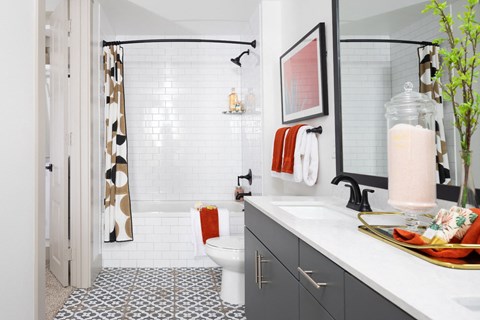 A bathroom with a toilet, sink, and a mirror.
