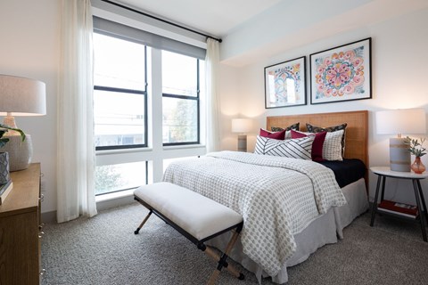 A bedroom with a large bed and a bench in front of it.
