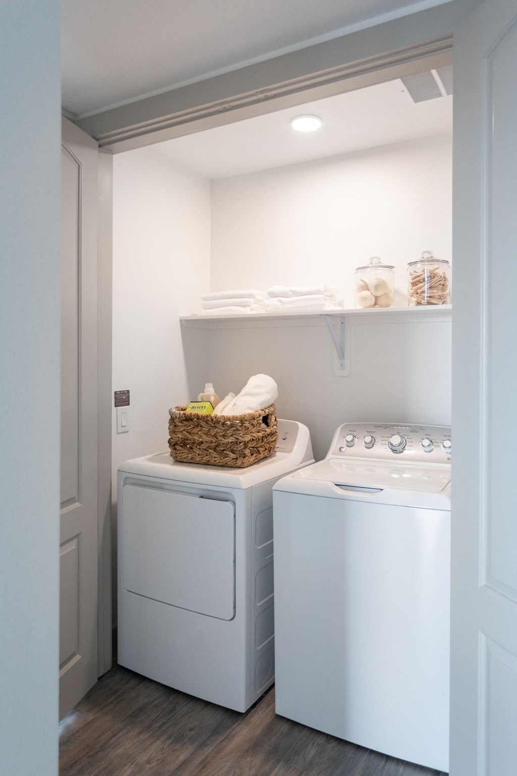 a white washer and dryer in a laundry room with a basket on top