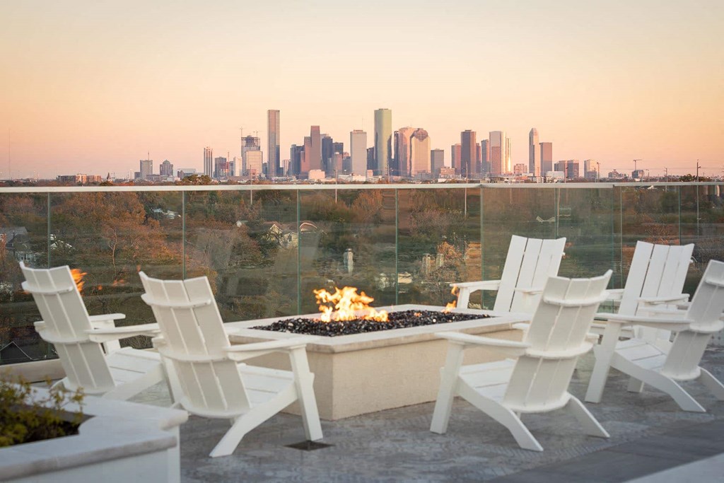 a terrace with a fire pit and a view of the city