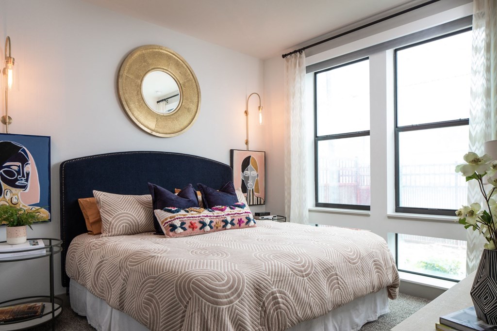 a bedroom with a large bed and a mirror on the wall