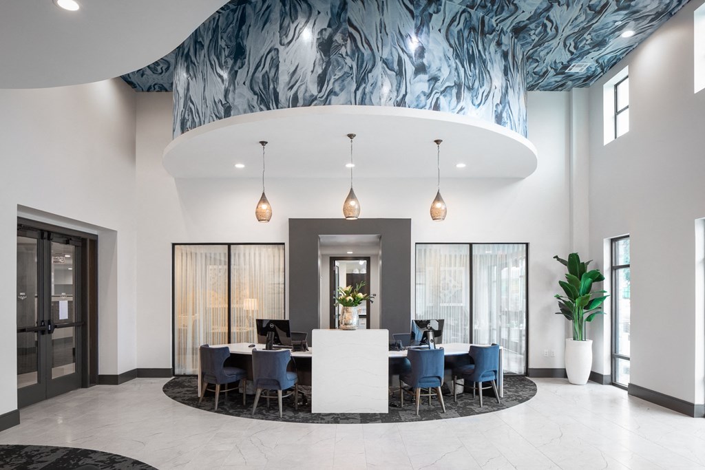 a large room with a table and chairs and a blue and white ceiling