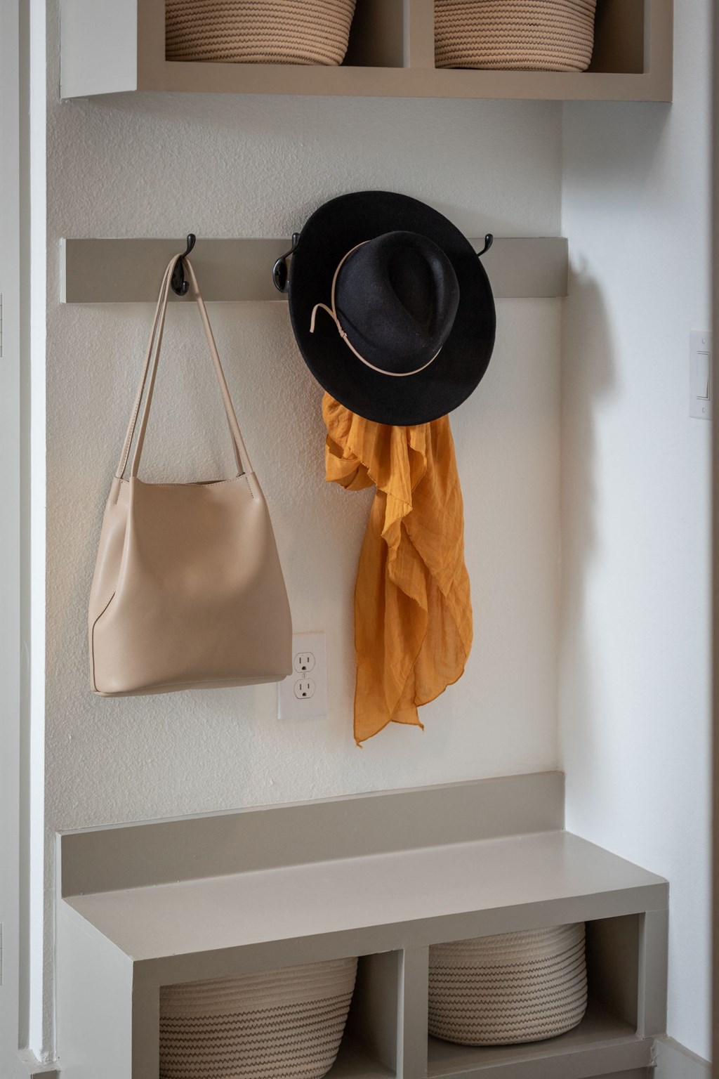 a shelf with baskets and a hat and a purse on it