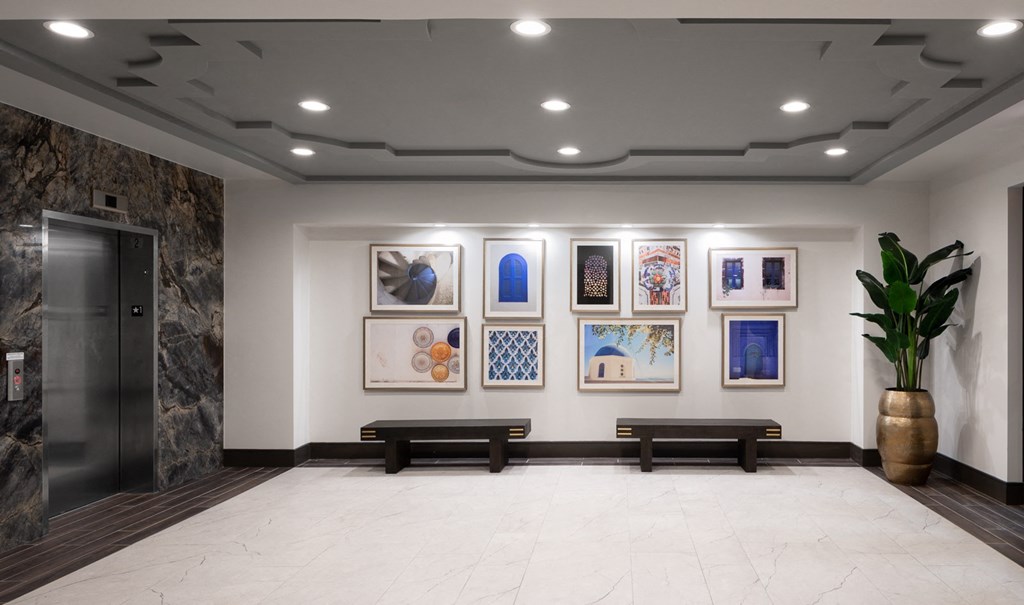 a lobby with paintings on the wall and benches
