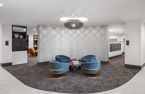 a lobby with blue chairs and a round table