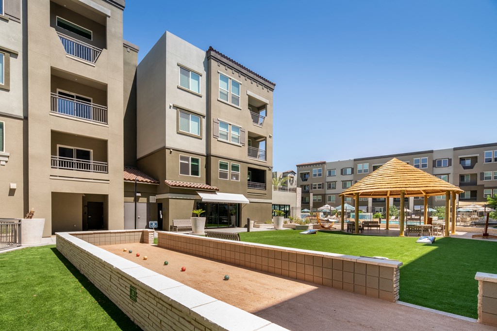 a backyard with a pool and a lawn with a gazebo and apartments