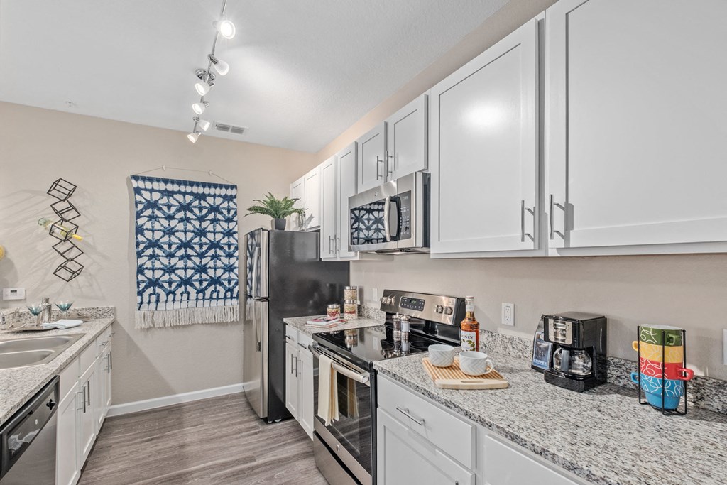 a kitchen with white cabinets and stainless steel appliances