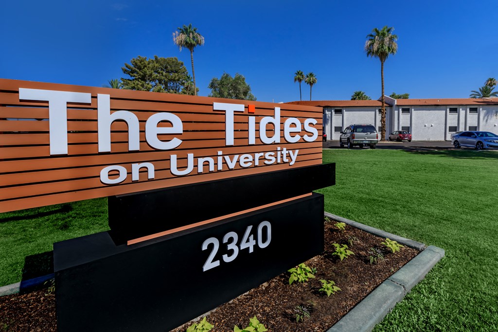 a sign with the words the tides on university on it in front of a building