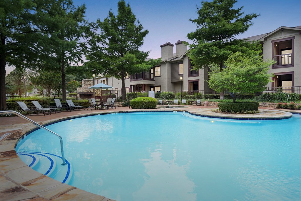 a swimming pool with an apartment building in the background
