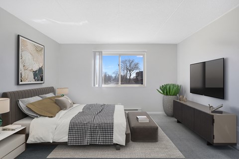 an open bedroom with a bed and a tv on the wall