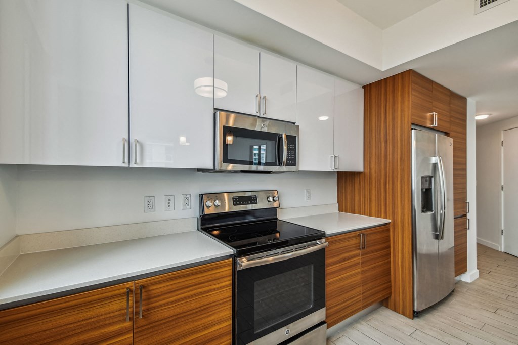 a kitchen with white countertops and wooden cabinets