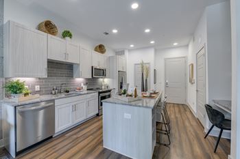 A modern kitchen with white cabinets and a central island.