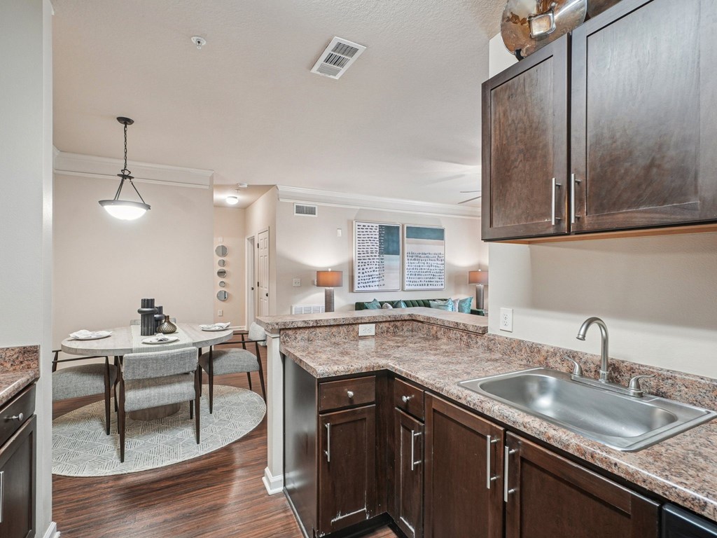 A kitchen with brown cabinets and a granite countertop.