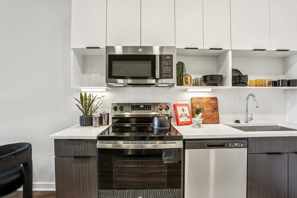 A modern kitchen with a stove top oven and microwave above it.