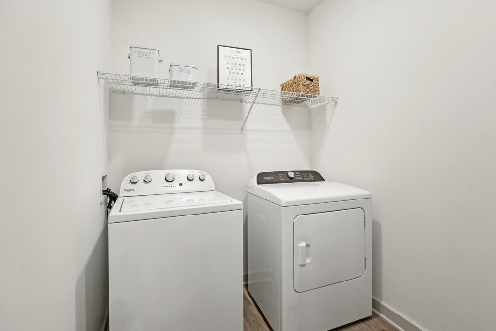 A white dryer and washing machine in a laundry room.