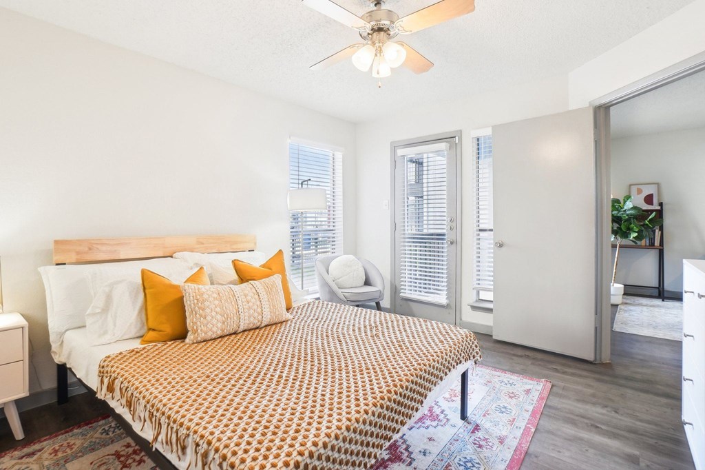 A bedroom with a bed, a ceiling fan, and a rug.