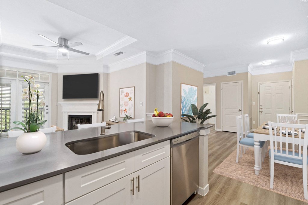 a kitchen with a sink and a living room with a dining room
