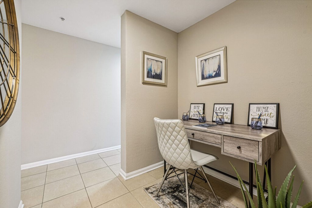 A white chair is in front of a desk with a mirror above it.